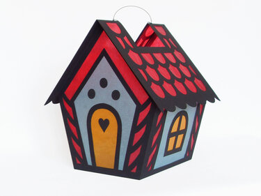 Hausförmige Papierlaterne in Rot, Blau und Gelb mit herzförmiger Tür und Drahtbügel
