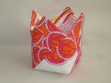 Quadratisches Stoffutensilo mit orange-rosa Muster und gefalteten, gezackten Ecken