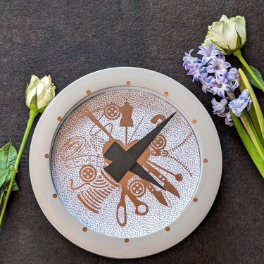 Plottdatei mit Nähmotiven (Schere, Knopf, Garnrolle, Schneiderpuppe) kreisförmig um ein Herz, dargestellt als Zifferblatt einer Uhr.