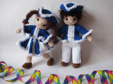 Zwei gehäkelte Amigurumi-Puppen in blau-weißen Karnevalskostümen vor hellem Hintergrund
