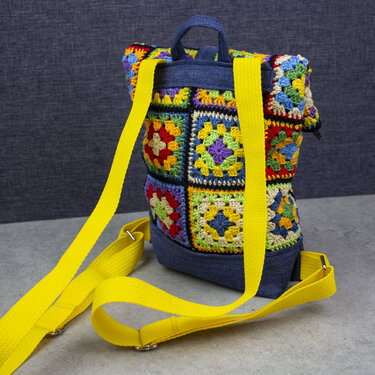 Bunter Häkelrucksack aus Granny-Squares mit jeansblauem Boden und gelben Trägern