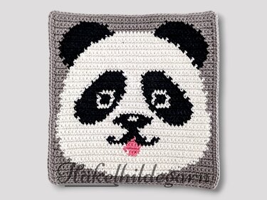 Gehäkeltes Pixelquadrat mit Panda-Gesicht in Weiß, Schwarz, Grau und rosa Zunge