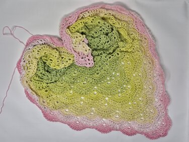 Gehäkeltes dreieckiges Tuch mit verlaufendem Garn in Grün, Gelb und Rosa, Lochmuster und Muschelkante