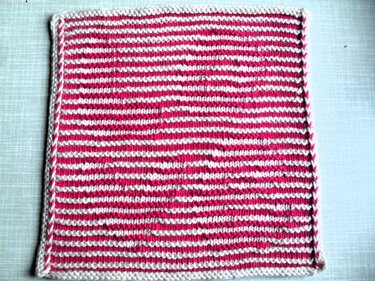 Quadratisches gestricktes Stück mit rosa-weißen Streifen und weißem Rand