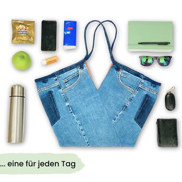 Jeans‑Einkaufstasche im Upcycling‑Look mit V‑Schnitt, flach gelegt und umgeben von typischen Alltagsgegenständen wie Thermosflasche, Apfel, Sonnenbrille, Geldbörse und Handy