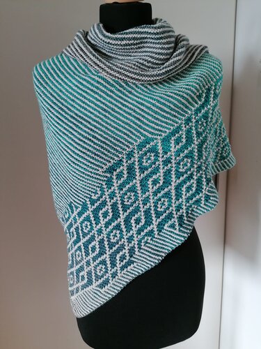 Gestricktes Dreieckstuch in Petrol und Hellgrau mit diagonalen Streifen und Rautenmuster auf einer schwarzen Schaufensterpuppe.