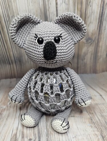 Gehäkelter grauer Amigurumi-Koala mit Netzbauch und sichtbaren Perlen