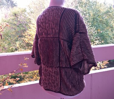 Rückansicht eines gestreiften Damenpullovers in Bordeaux und Creme mit weiten Fledermausärmeln an einer Schaufensterpuppe