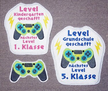 Zwei bestickte Einschulungs-Aufnäher mit Game-Controller, Blitzsymbolen und Texten für 1. und 5. Klasse plus kleiner Controller-Aufnäher