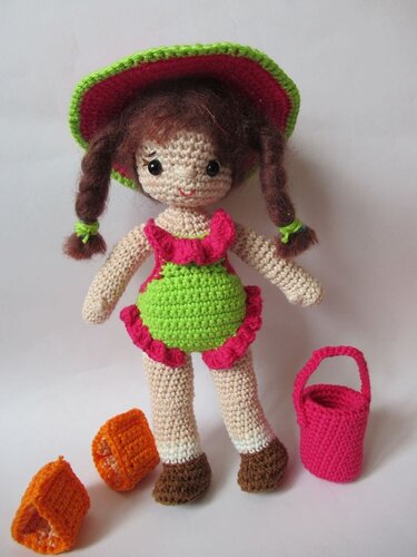 Amigurumi-Puppenkleidung: grün-pinkes Outfit mit Rüschen, Hut, Schühchen und Körbchen.