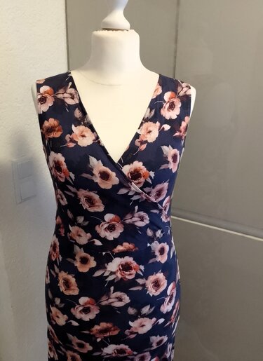 Ärmelloses dunkelblaues Wickelkleid mit rosa Blumenmuster auf Schneiderpuppe