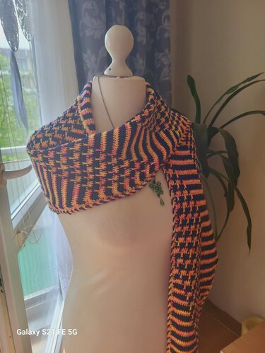 Gehäkeltes Dreieckstuch in schwarz mit orange-pinken Streifen an einer Schneiderpuppe drapiert