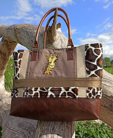 Tasche mit Materialmix: lederähnlicher Boden, Giraffenmuster-Einsätze und gestickte Giraffenkopf-Applikation