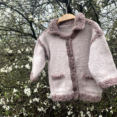 Kinderjacke gestrickt mit glattem Muster, flauschigem Rand, Knopfleiste und zwei aufgesetzten Taschen