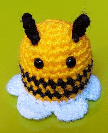 Gehäkelte gelb‑schwarze Biene mit weißen Details