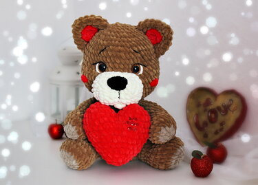 Gehäkelter Teddybär mit rotem Herz, samtartiger Garnstruktur und detailreichen Elementen