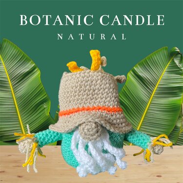 Gehäkelter Wichtel mit beigem Hut, orangefarbener Hutborte, weißem Bart und türkisfarbenen Armen mit gelben Stroh-Details auf Holz