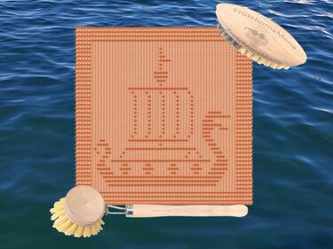 Oranges gestricktes quadratisches Tuch mit Schiffsmotiv und zwei Holzbürsten auf Wasserhintergrund