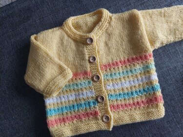 Gelbe gestrickte Babyjacke mit bunten Streifen, Knopfleiste und Holzknöpfen
