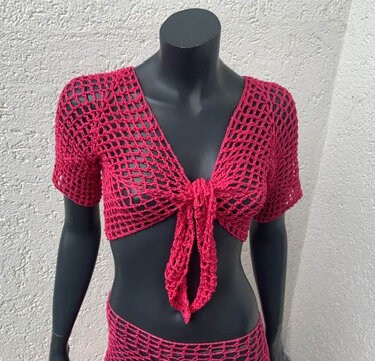 Pinker gehäkelter, kurz geschnittener Bolero mit offenem Netzmuster und Knoten vorne auf schwarzem Mannequin