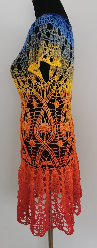 Gehäkelte Damen-Tunika mit Farbverlauf in Blau, Gelb, Orange und Rot auf schwarzer Schaufensterpuppe