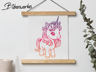 Outline-Illustration eines niedlichen Einhorns mit lila‑pink‑orange Farbverlauf auf weißem Papier in Holzposterhalter