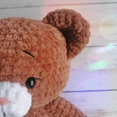Nahaufnahme brauner gehäkelter Amigurumi-Teddykopf mit weißer Schnauze