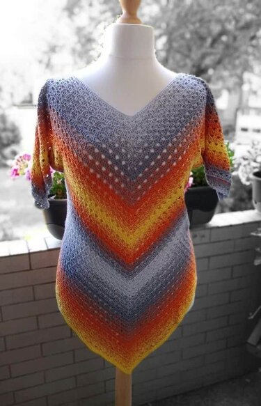 Kurzärmelige gehäkelte V‑Tunika mit Chevron‑Farbverlauf in Grau, Orange und Gelb auf Schaufensterpuppe