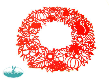 Roter Plott-Kranz mit ausgeschnittenen Blättern, Kürbissen, Pilzen und Eichhörnchen auf weißem Hintergrund.