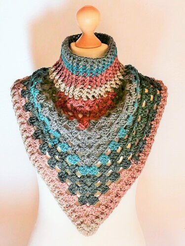 Gehäkelter Kragenschal mit hohem Kragen in bunten Streifen aus Rosa, Türkis, Grau und Rosttönen auf einer weißen Schaufensterpuppe.
