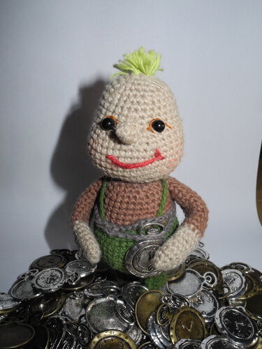 Gehäkelte Amigurumi-Puppe mit grünem Haar und Latzhose auf Uhranhängern