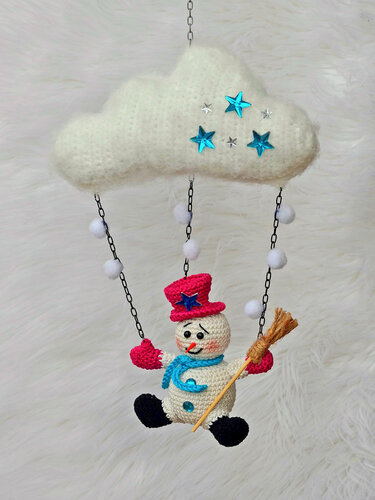Gehäkeltes Wolken-Mobile mit blauen Sternen und hängendem Schneemann mit pinkem Hut