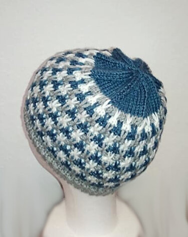 Gestrickte blau-weiße Beanie mit geripptem Bund auf einem Schaufensterkopf, Rückansicht