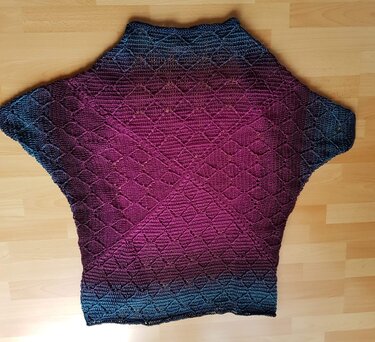 Gehäkelter Seelenwärmer in Blau-Magenta mit Rautenmuster auf Holzboden