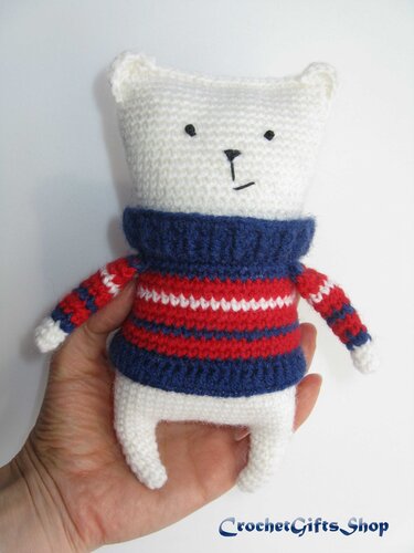 White amigurumi bear in navy and red striped turtleneck sweater, held in hand