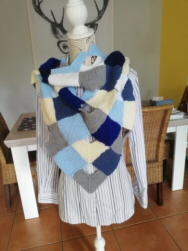 Gestricktes Patchwork-Dreieckstuch aus verbundenen Quadraten in Blau-, Grau- und Cremetönen auf Schneiderpuppe