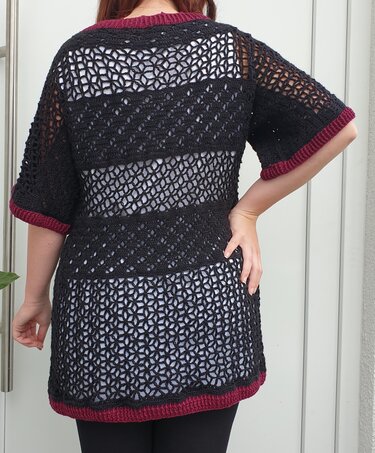 Schwarzer gehäkelter Damen-Pullover mit Lochmuster und bordeauxroten Bündchen, Rückenansicht.