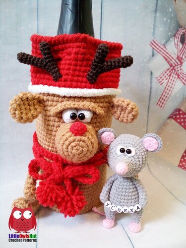 Crocheted reindeer bottle cozy in brown, red, and white, with a small grey amigurumi mouse.