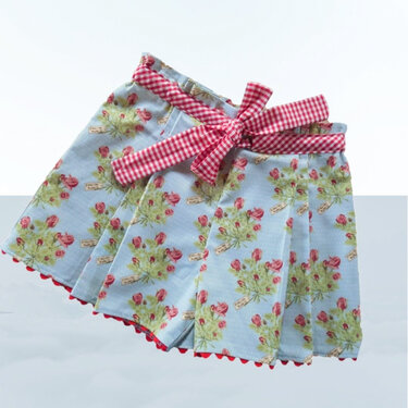 Hellblauer Kinderrock mit Rosenprint, weißen Punkten, rot-weiß kariertem Bund, Schleife und rotem Wellensaum