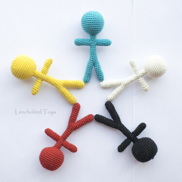 Five crocheted amigurumi stick dolls in blue, yellow, cream, red, and black on white background