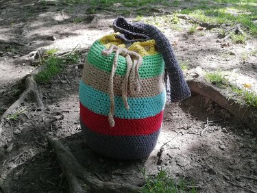 Gehäkelte Beuteltasche mit horizontalen Streifen in Grau, Rot, Türkis, Beige und Grün, Kordelzug und Trageriemen