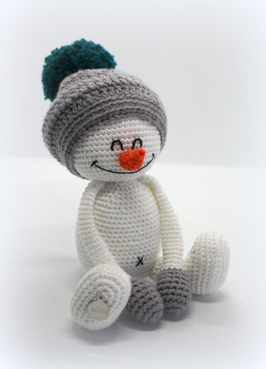 Gehäkelter Amigurumi-Schneemann mit grauer Bommelmütze und orangefarbener Nase