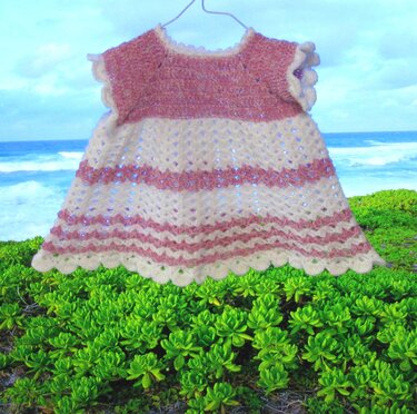 Gehäkeltes A‑Linien‑Babykleid in Creme und Rosa mit Lochmuster und Muschelsaum