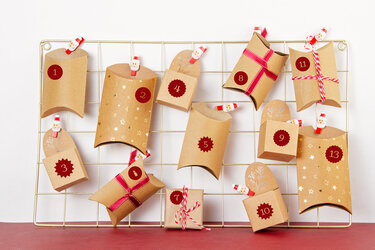Nahaufnahme eines Adventskalenders mit nummerierten Papiertüten und Weihnachtsclips