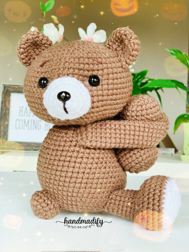 Close-up of brown crocheted amigurumi teddy bear showing stitch texture, shaping, and white snout
