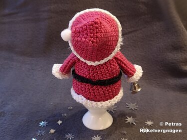 Gehäkelter Weihnachtsmann-Eierwärmer in Rot und Weiß auf Eierbecher, Rückansicht mit Glöckchen