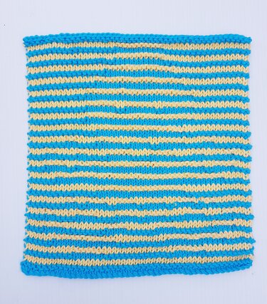 Gestricktes Quadrat mit türkisen und hellgelben Streifen