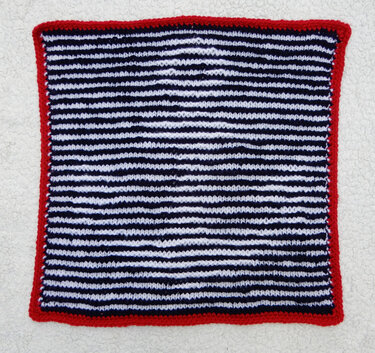 Quadratisches glattrechts gestricktes Streifenmuster in blau-weiß mit rotem krausrechts Rand