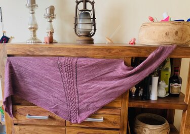 Gestricktes Dreieckstuch in Mauve mit mittigem Noppenstreifen, das Maschenbild ist deutlich zu sehen