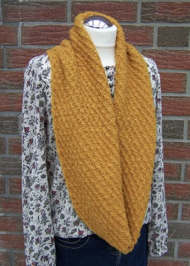 Senfgelber gestrickter Loop-Schal mit Strukturmuster auf Schaufensterpuppe